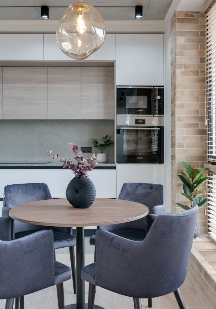 Contemporary dining space featuring a round table, upholstered chairs, and stylish decor.